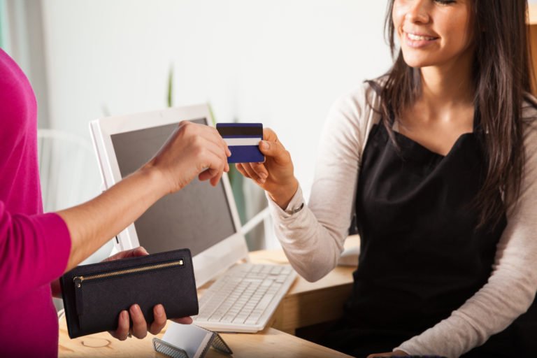 Frau übergibt Kreditkarte Kassensoftware Einzelhandel