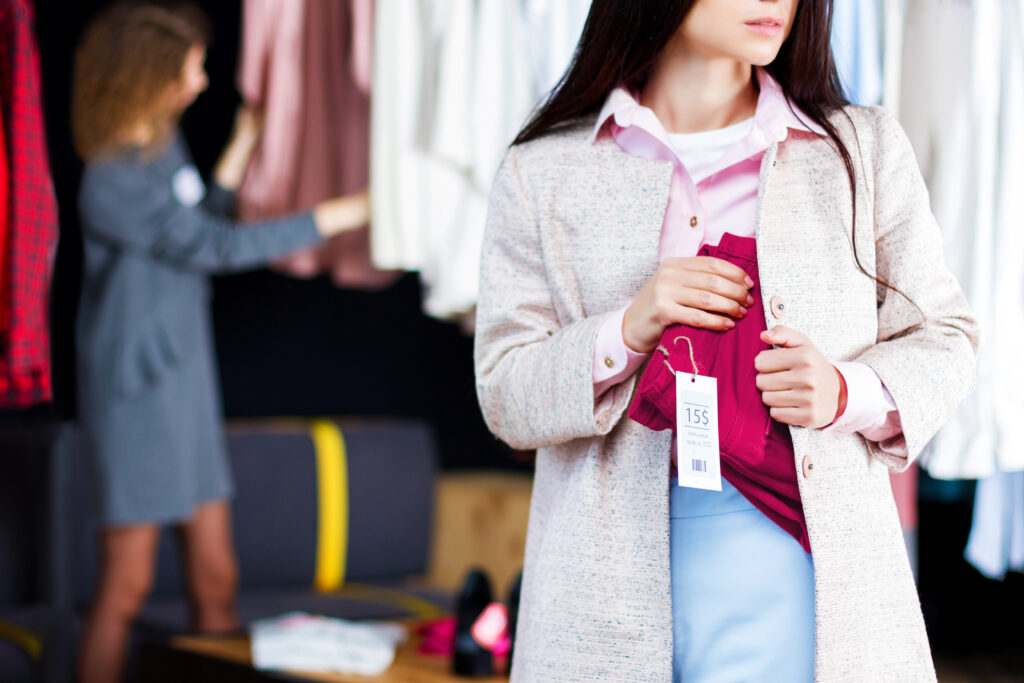 Junge Frau stiehlt rote Jeans Ladendiebstahl