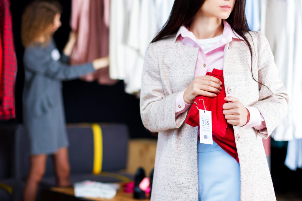 Junge Frau stiehlt rote Jeans Ladendiebstahl