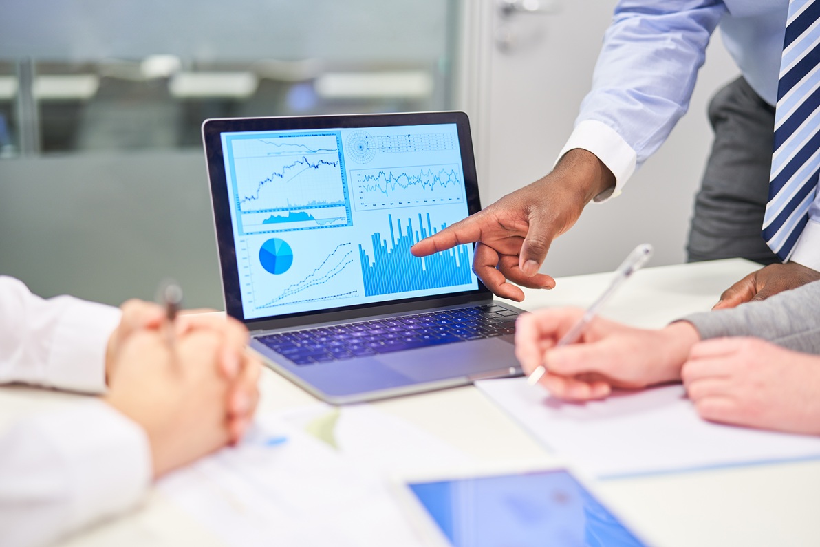 Manager als Berater zeigt auf Diagramm am Computer Monitor bei der Finanzanalyse